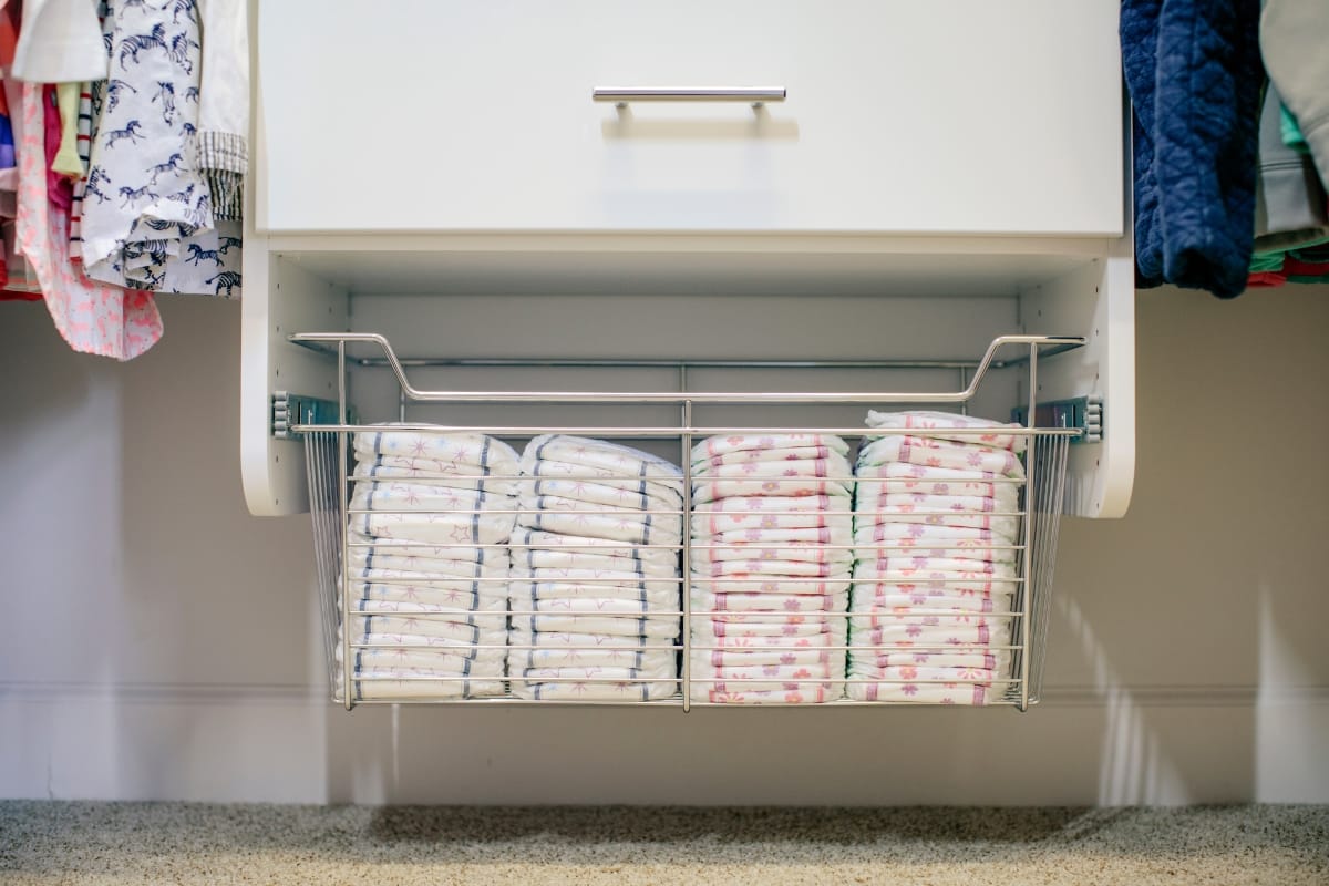 Diapers placed in pull out basket under drawer