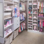 Girls walk in closet with clothing on racks and shelves