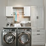 Laundry closet showing rack for hanging clothing as well as space for washer and dryer