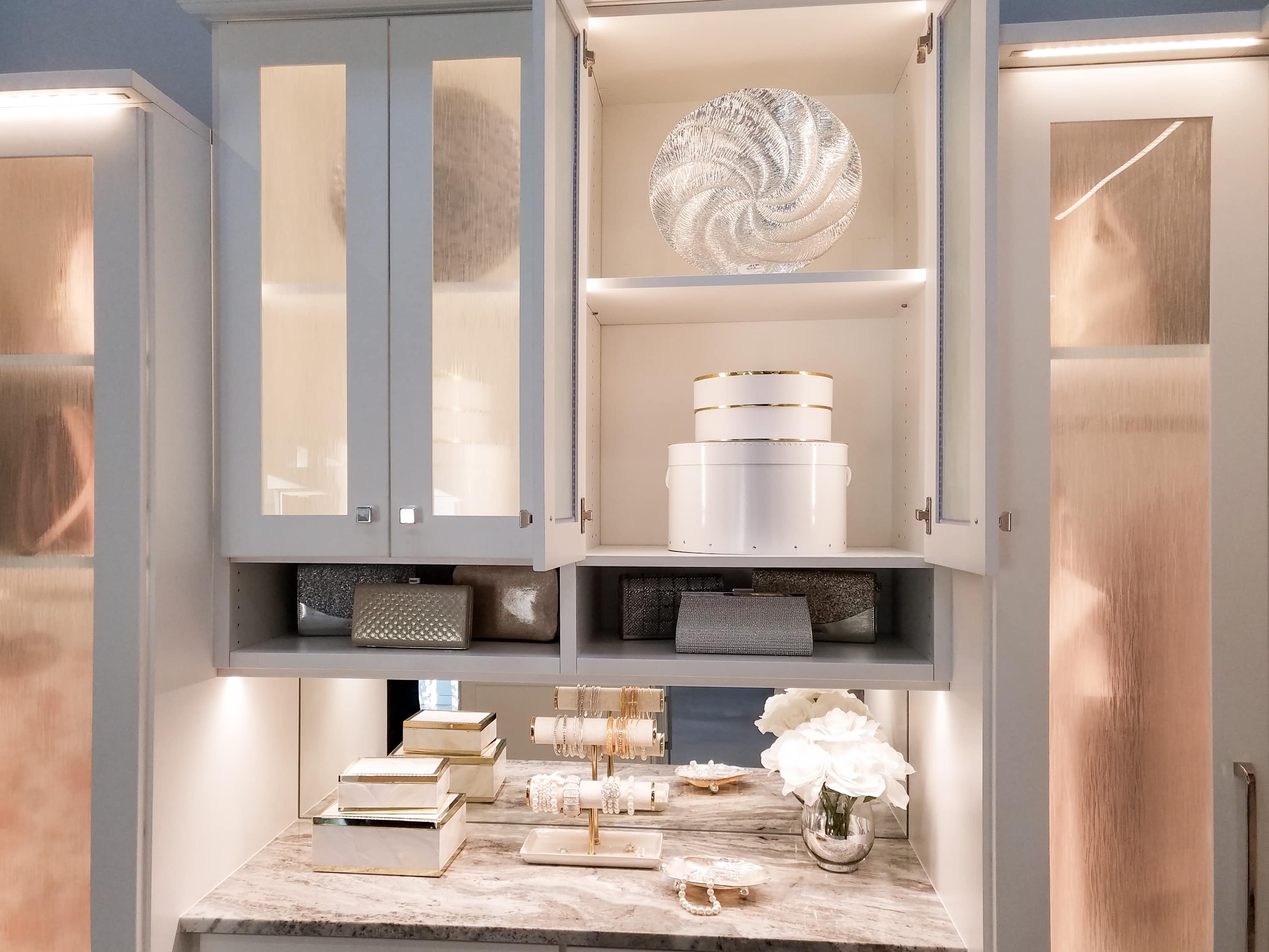 Closet showing glass cabinets with belongings on shelves