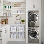 Custom floor mounted boutique laundry room storage with shelving and hampers