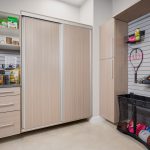 Custom wall mounted garage storage in driftwood with sliding cabinet doors in Vero Beach, Florida